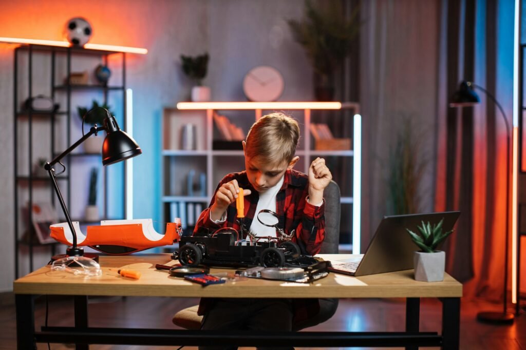 Boy repairing remote controlled toy car with screwdriver